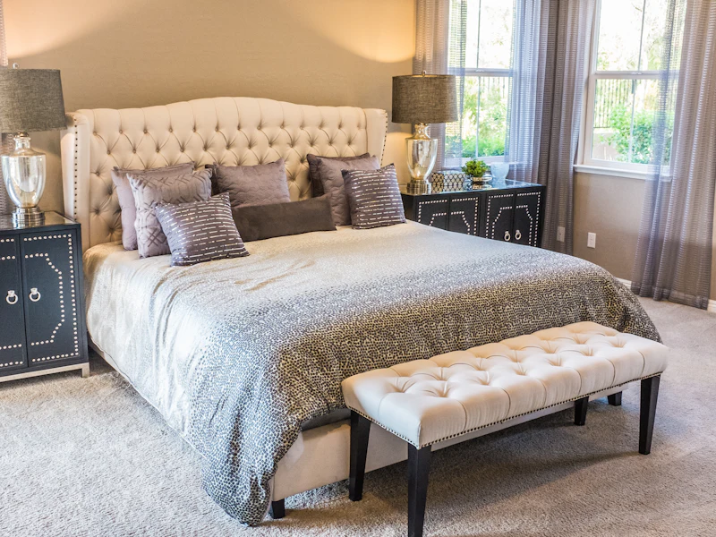 Neatly made bed in a bright, welcoming guest bedroom